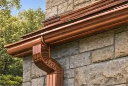 Copper gutter and downspout on a brick home