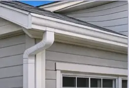 White vinyl gutter and downspout on a home with gray siding