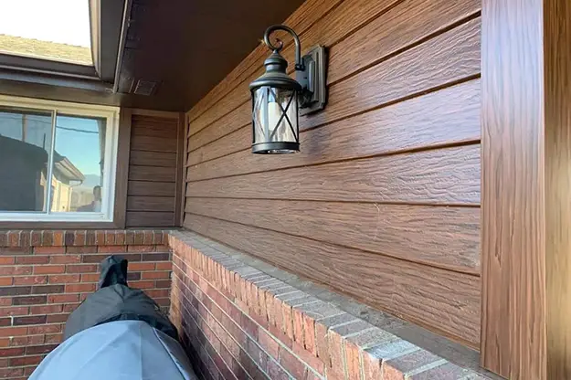 Stained wood siding on a home exterior beside a porch light