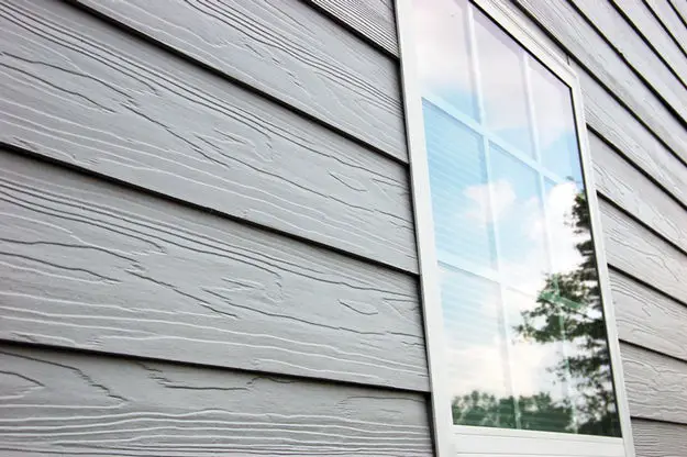 Gray fiber cement lap siding next to a window