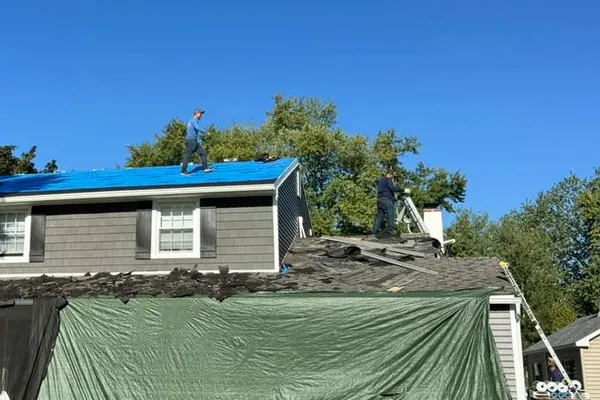 Blue tarp protecting a storm-damaged roof until repairs