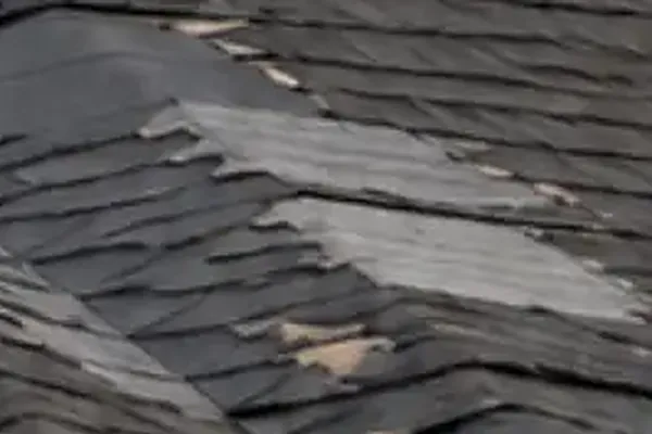 Close-up of storm damaged asphalt roof shingles
